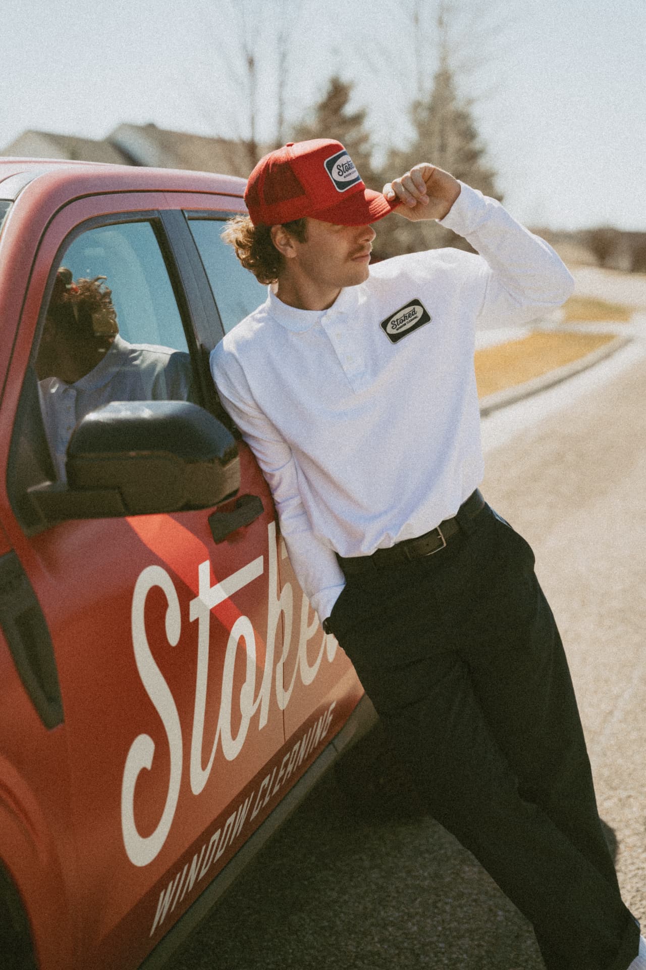 Stoked Window Cleaning technician leaning against the branded Stoked truck